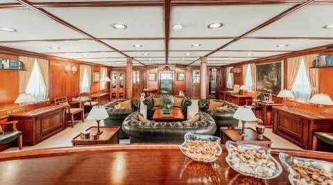 Interior of Seagull II yacht salon with wood paneling, seating, and table