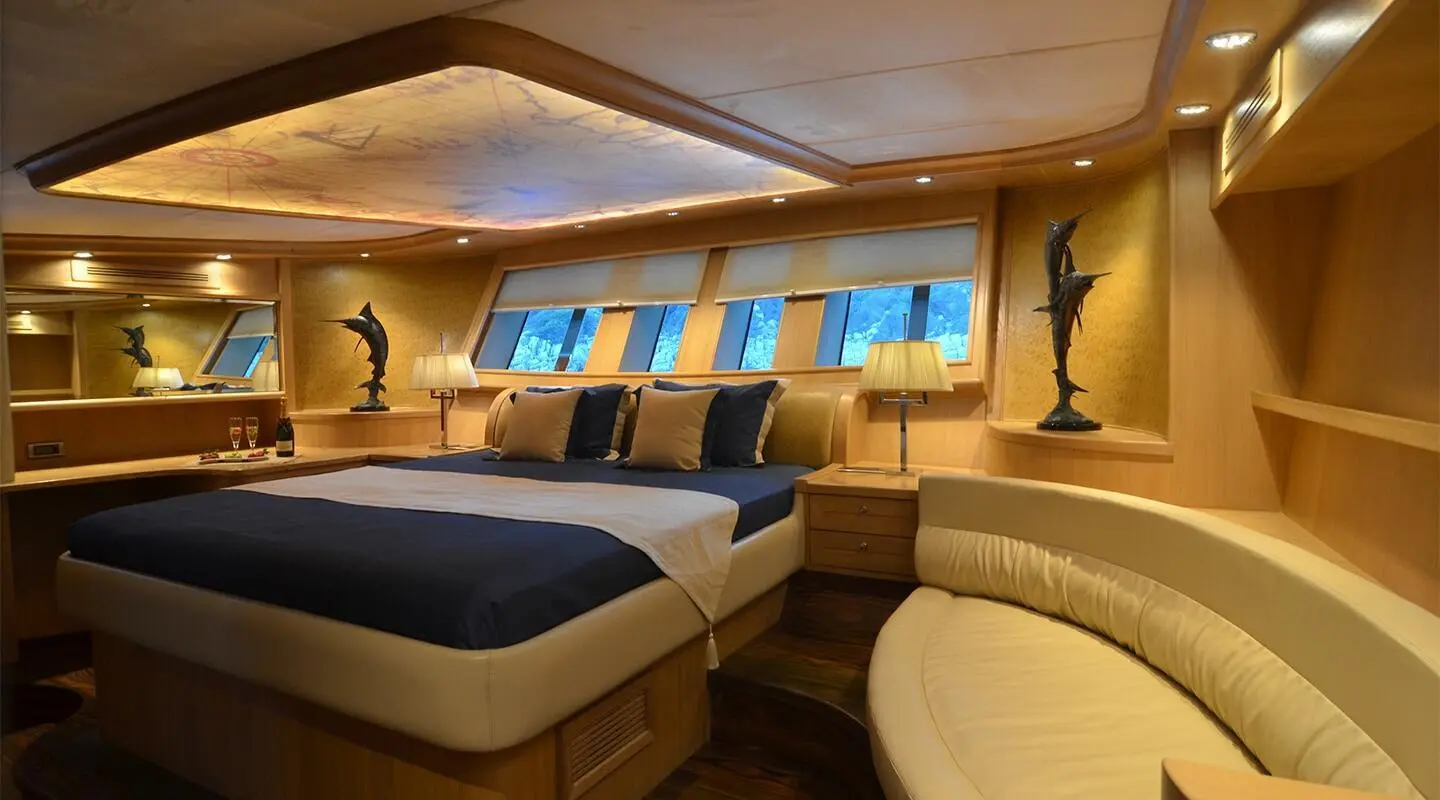 Interior of Blue Heaven gulet with two beds, wood paneling, and porthole windows