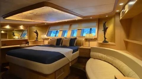 Interior of Blue Heaven gulet with two beds, wood paneling, and porthole windows