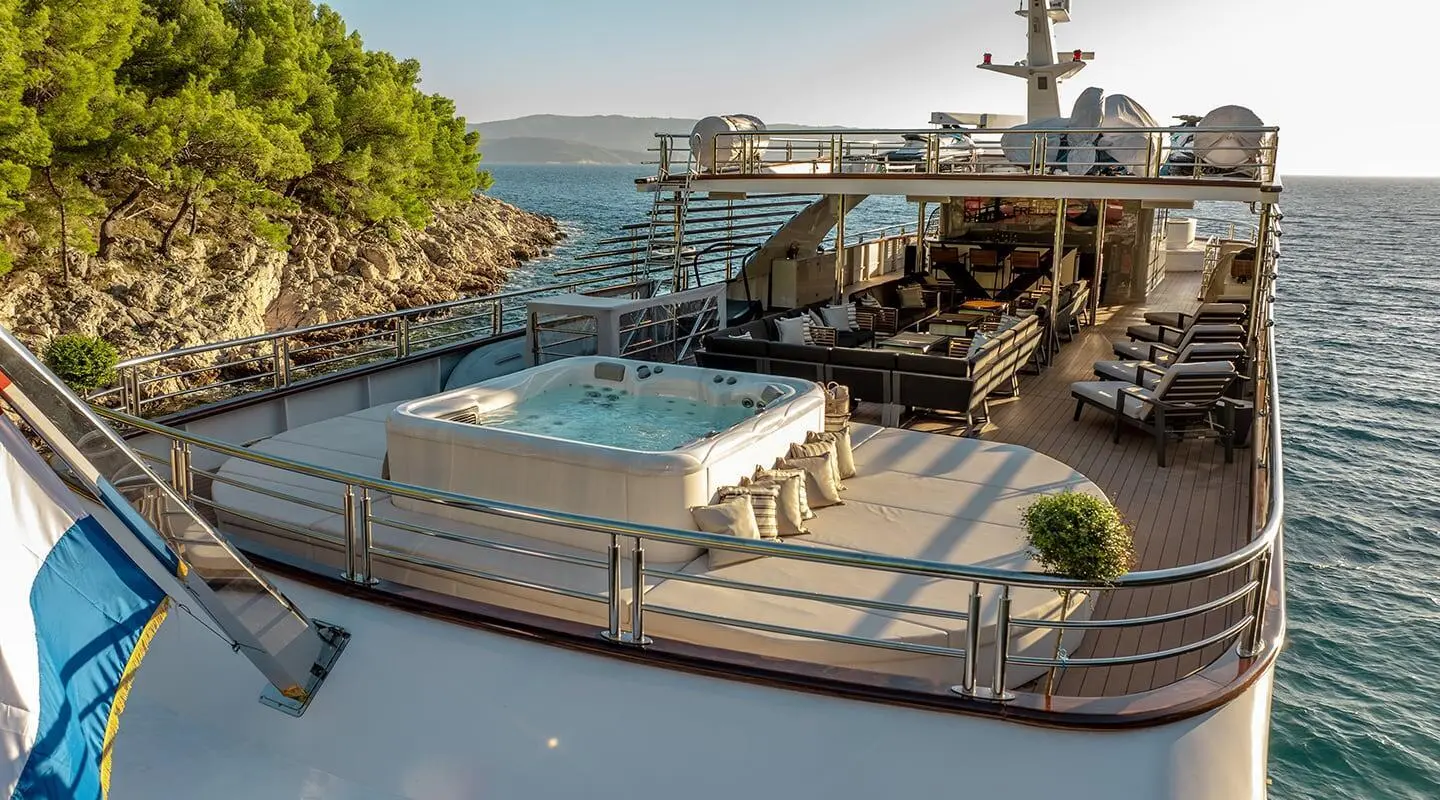 Yacht Freedom docked at sunset with deck seating and water view
