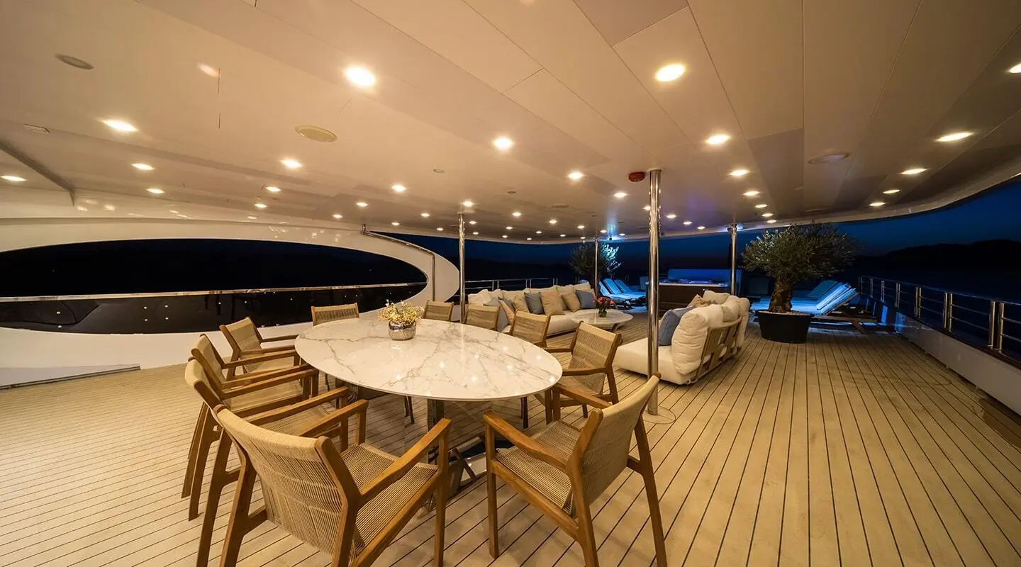 Lounge area of Olimp yacht with tables and chairs