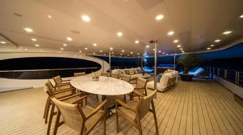 Lounge area of Olimp yacht with tables and chairs