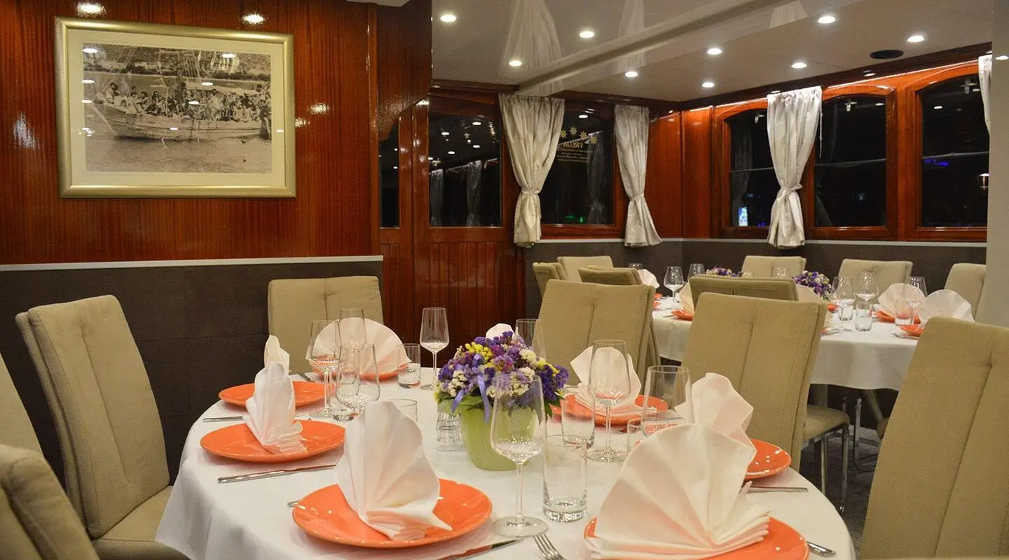 Tajna Mora yacht table set for dinner with white napkins and glassware onboard