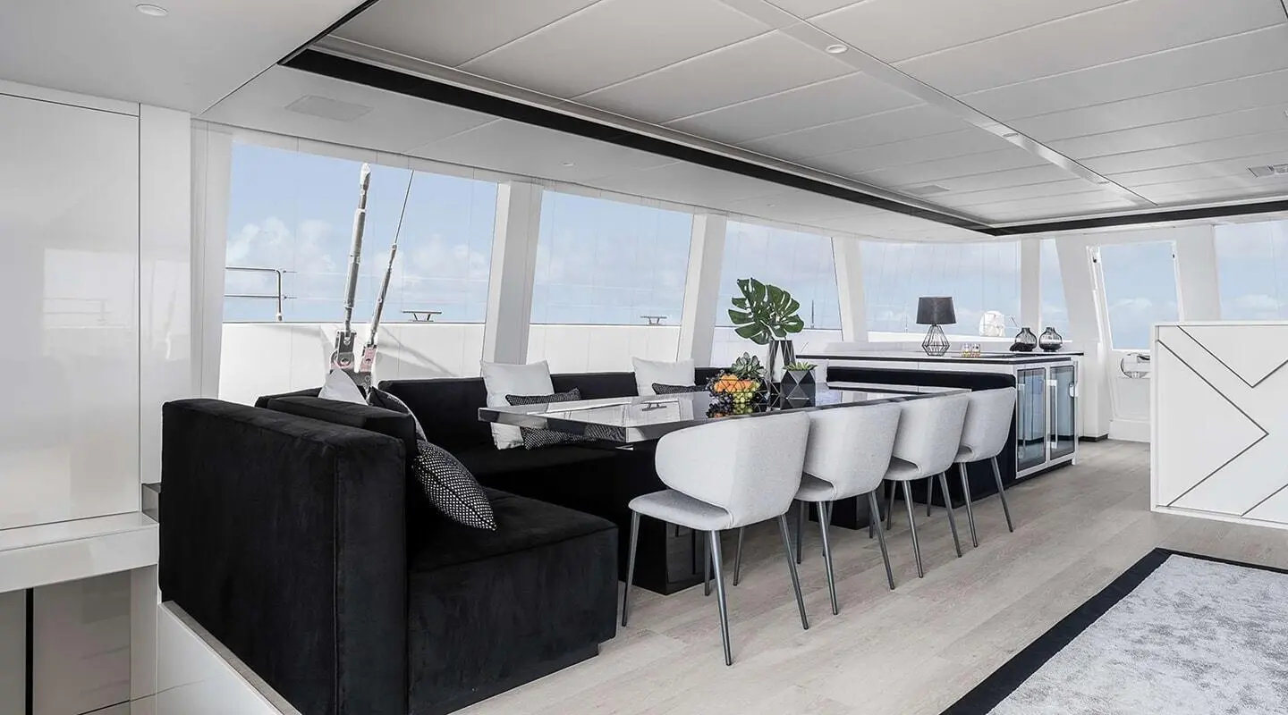 Spacious interior lounge with black sofas and gray chairs around a long dining table