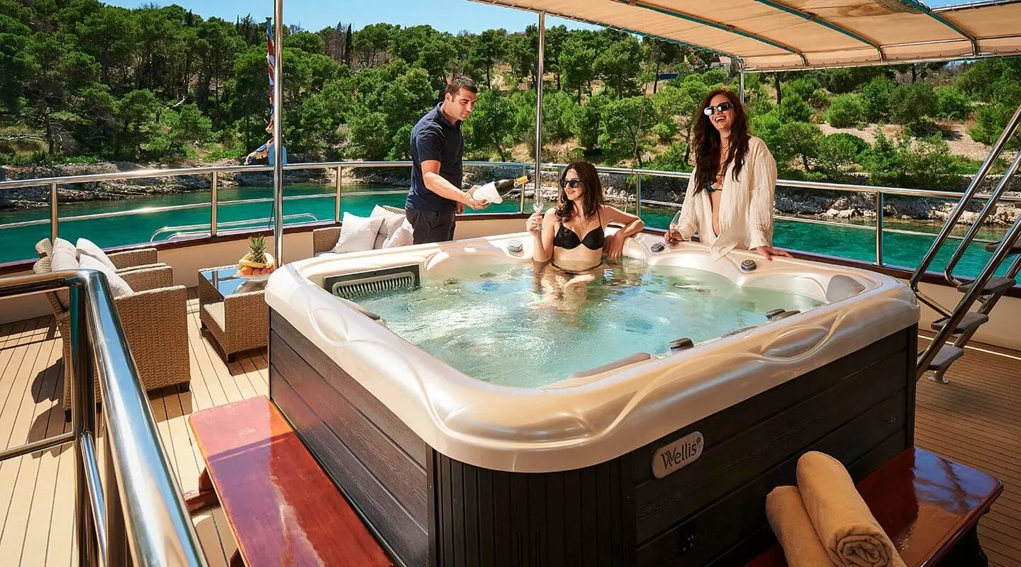 Luna motor yacht hot tub on deck with people enjoying sunset by water