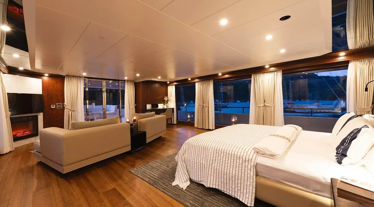 Interior of Ocean Breeze yacht with bed, seating, and warm lighting