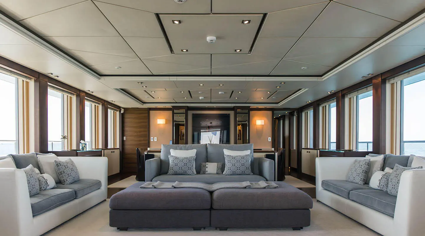 Luxurious yacht Alalya deck saloon with large bed, cushions, and warm lighting