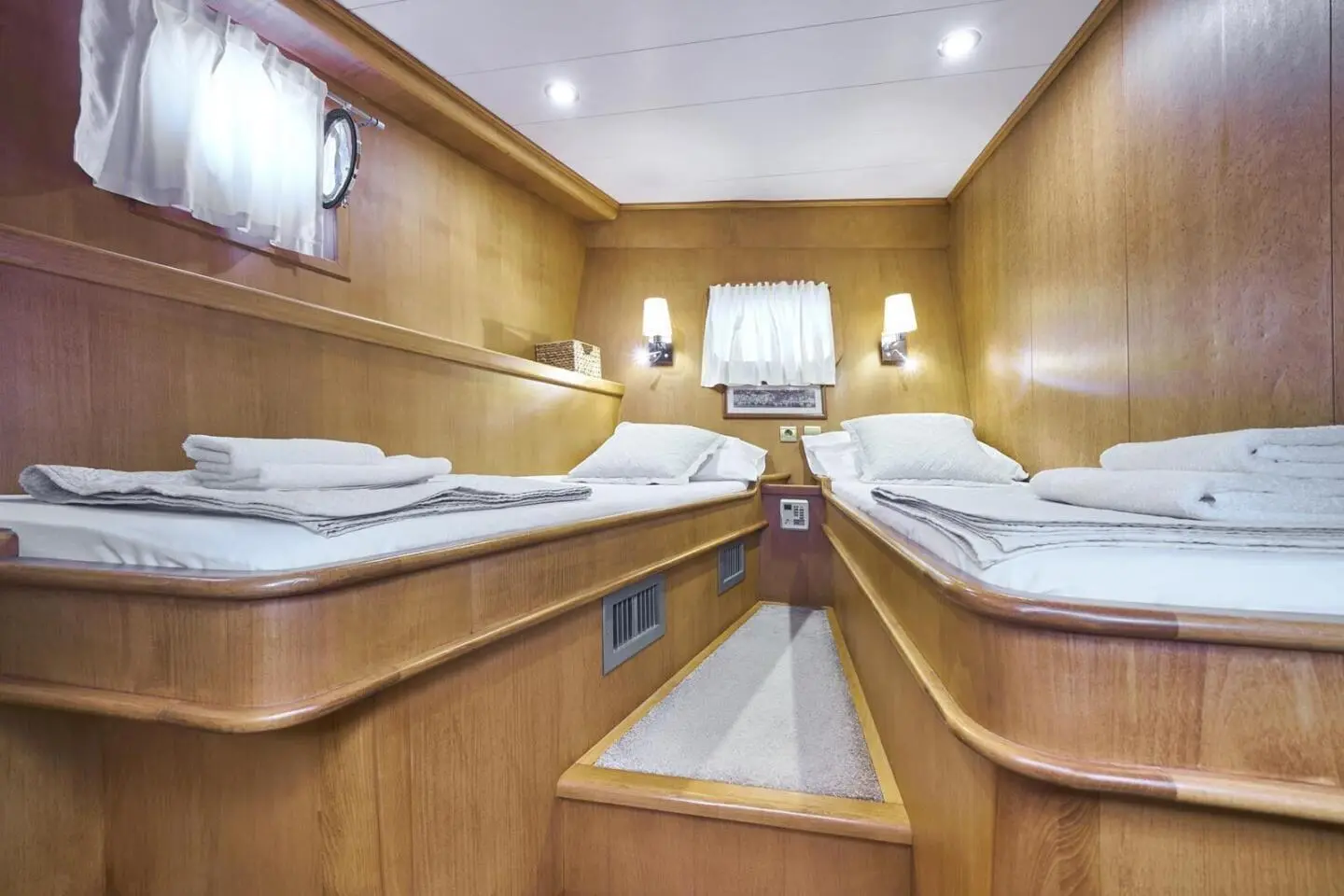 Interior of a wood-paneled yacht with bunks and a center aisle, Morning Star
