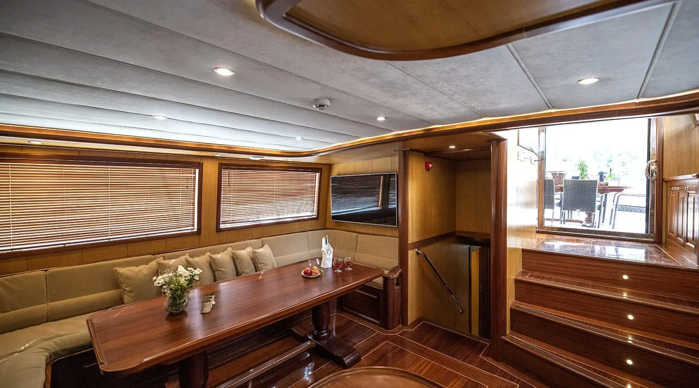 Kayhan 3 yacht interior with wooden cabinets, seating, and warm lighting reveal