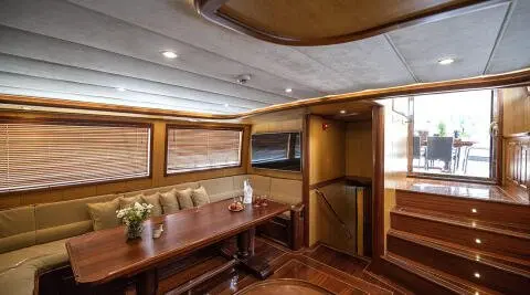 Kayhan 3 yacht interior with wooden cabinets, seating, and warm lighting reveal