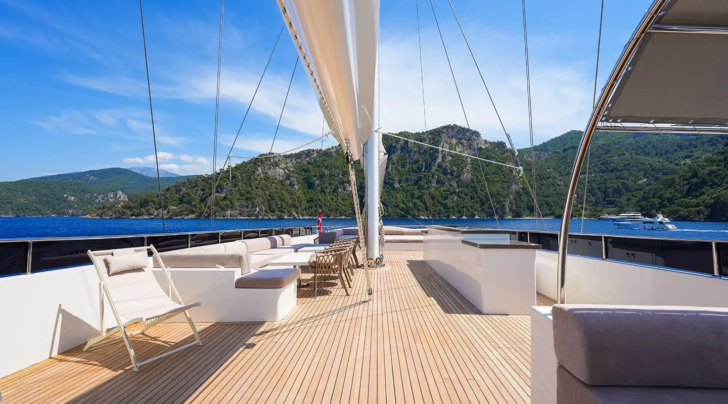 Sun deck of King Of The Sea yacht with ropes, wooden planks, and blue sea