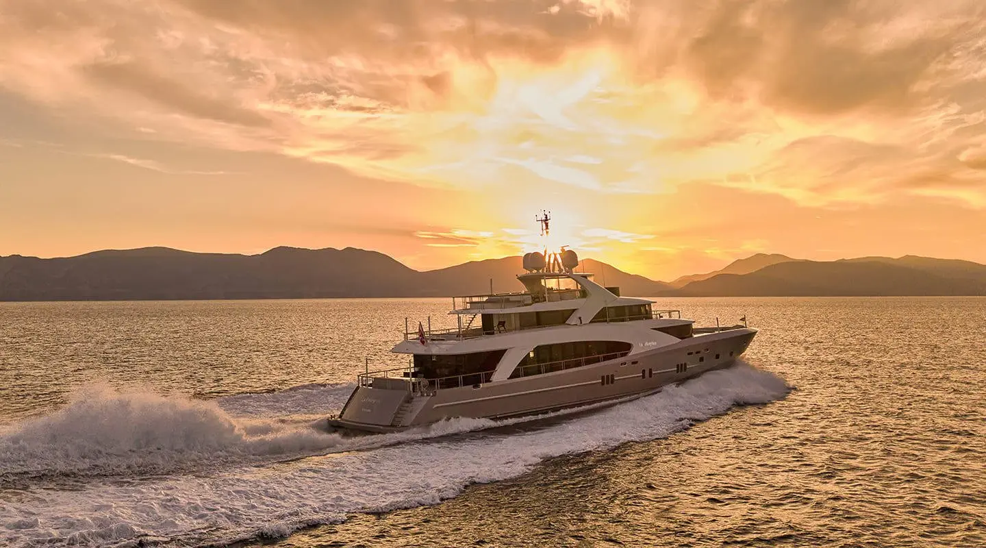 La Pellegrina 1 motor yacht cruising at sunset with warm sky and calm sea