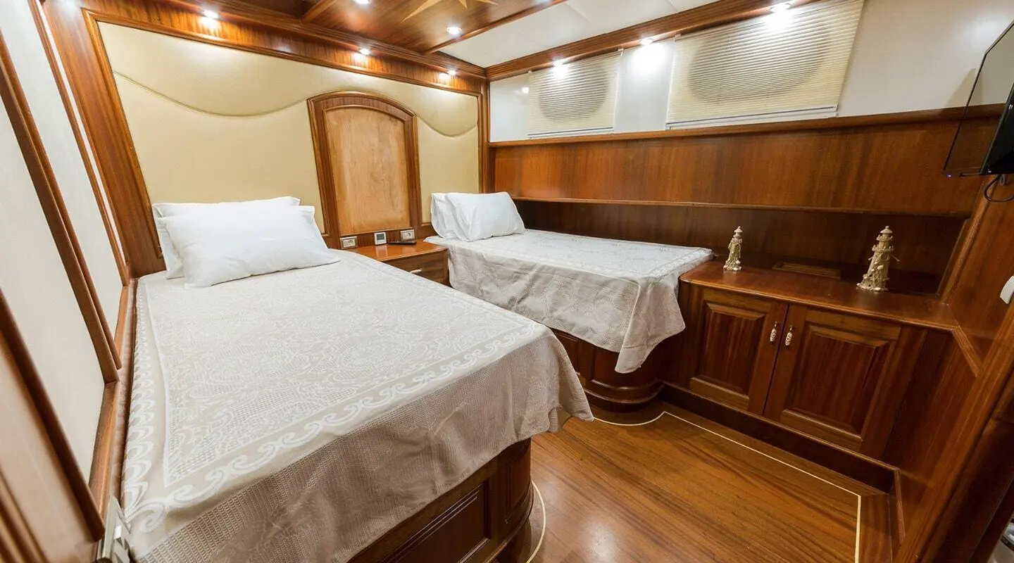 Halcon Del Mar yacht interior with two single beds and wood paneling