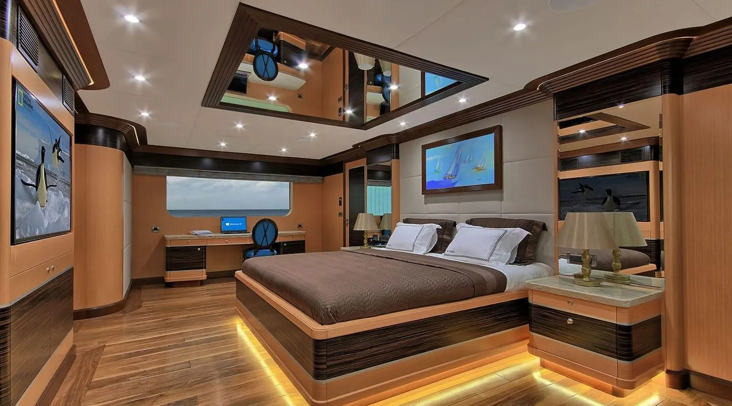 Meira yacht cabin interior with bed, seating area, wood accents, LED lighting