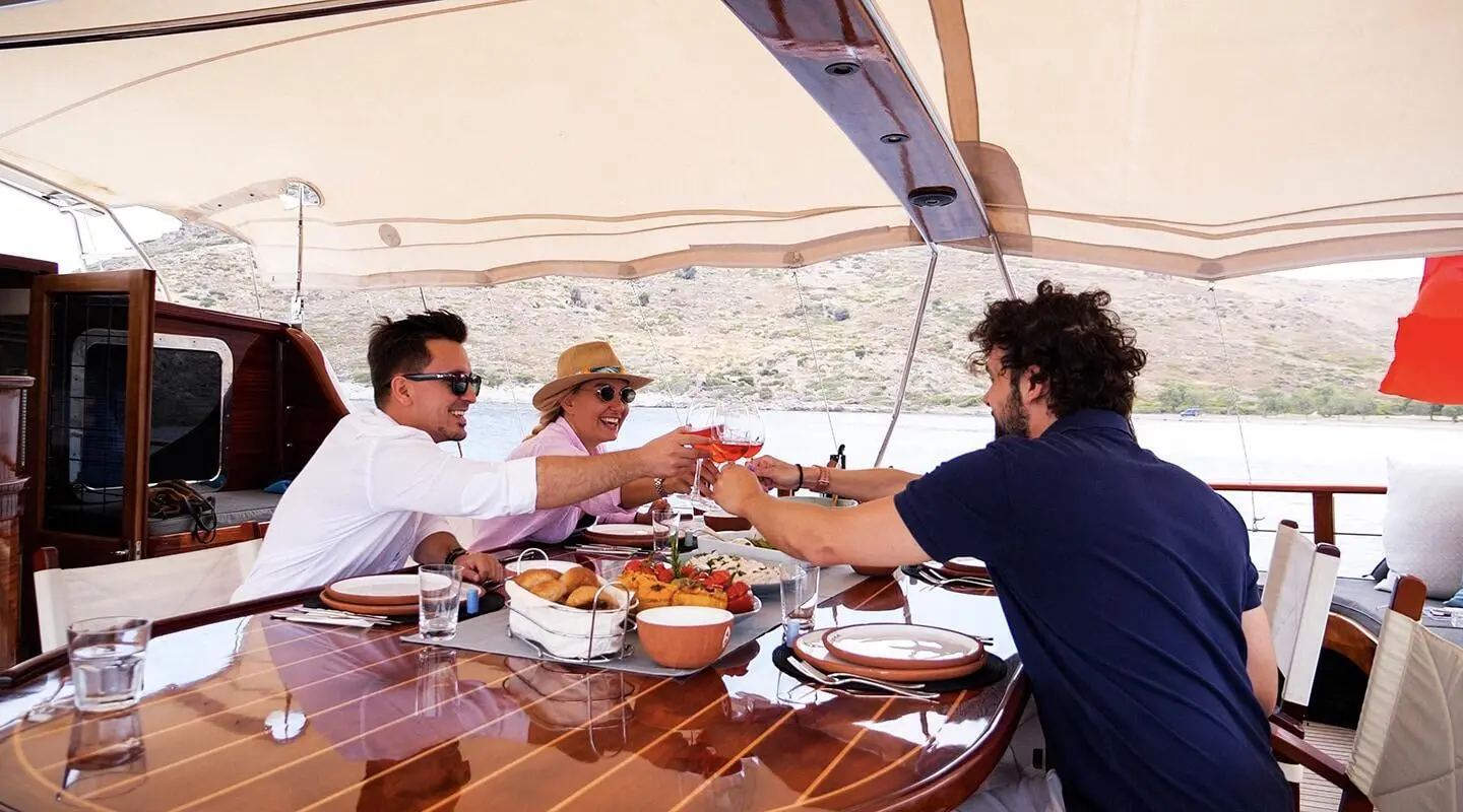 Cobra King yacht dining area with guests seated around a wooden table on deck
