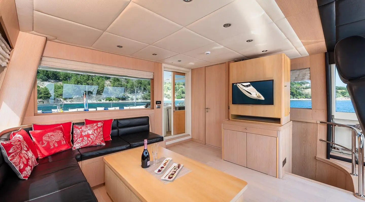 Interior of Grace yacht living area with wooden table, TV, and seating