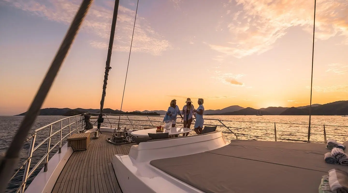 Angelo III yacht at sunset with guests on deck and calm sea