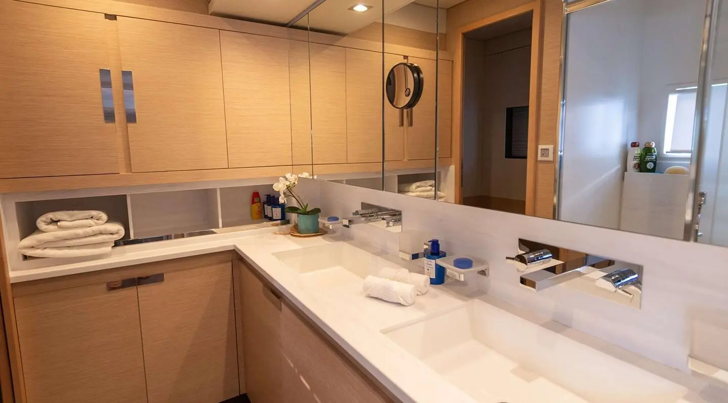 A yacht interior kitchen area with light wood cabinets and sink visible