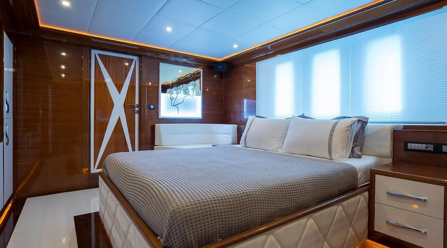 Gulet-style yacht interior with two double beds and wood paneling