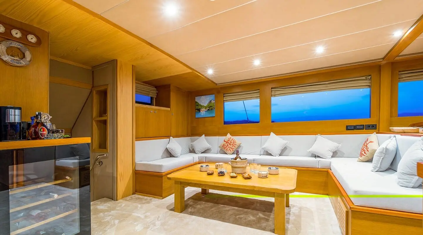 Interior of a luxury yacht salon with wooden furniture and large windows