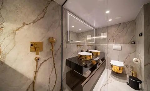 Nocturno yacht bathroom with marble walls, glass shower, and wooden accents