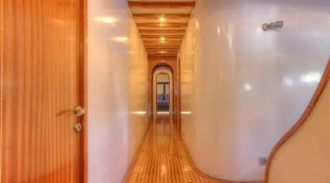 Angelo II gulet corridor with wooden floor and walls, a narrow passageway extending ahead