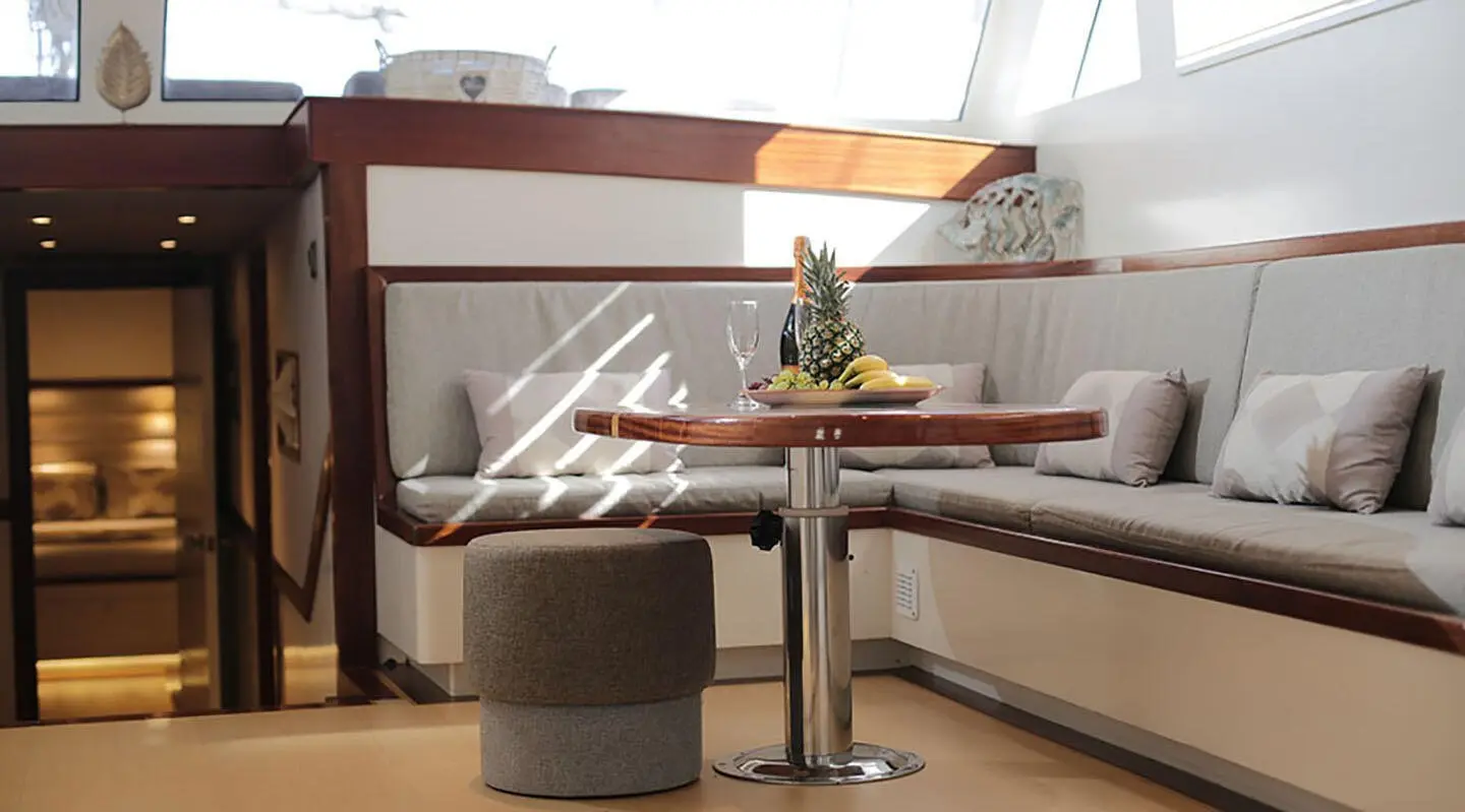 Interior yacht saloon on Grand Sailor, table set with flowers and seating