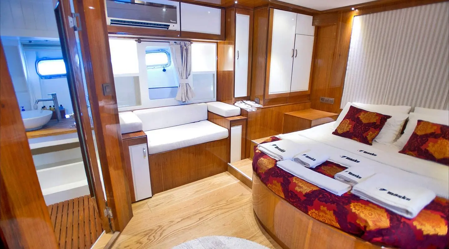 Maske 2 yacht interior with wooden furniture, seating area, and porthole view