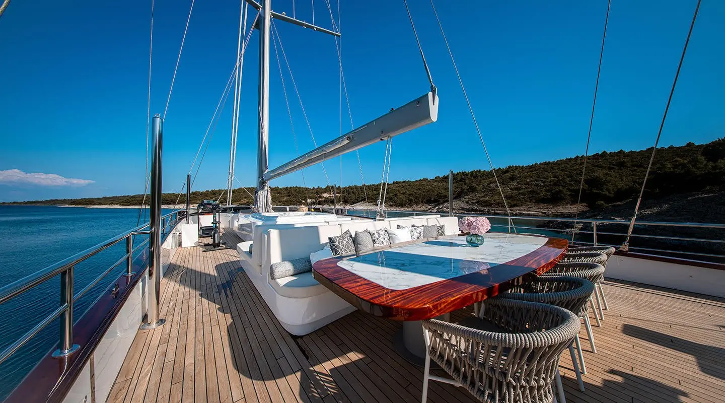 Nocturno motor yacht deck with sun loungers and a small red boat aboard on teak deck
