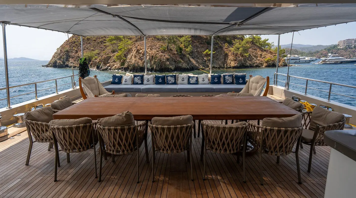 Deck scene aboard De Love yacht with teak floor, table, and chairs