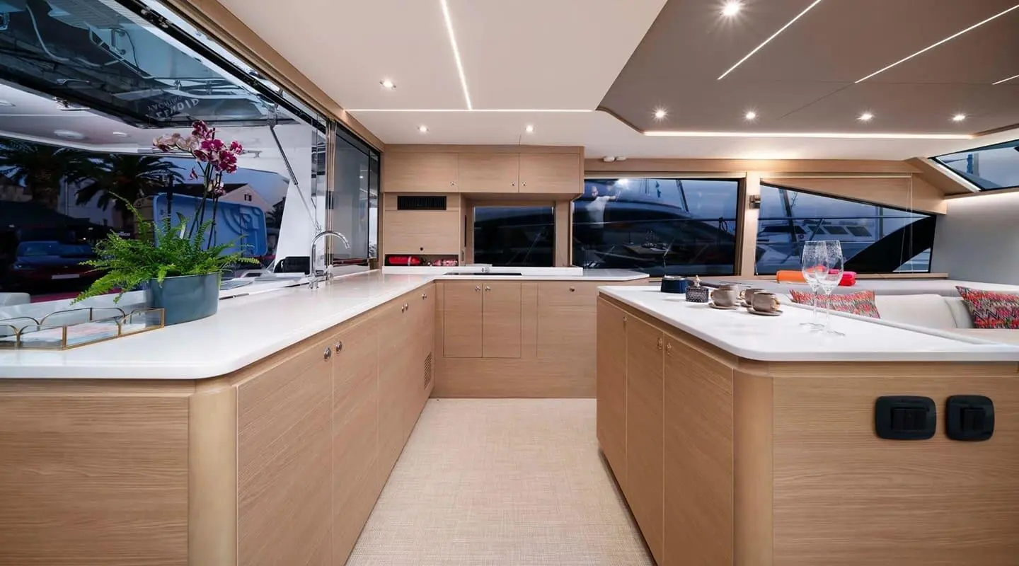Interior yacht galley at sunset with wooden cabinets and countertops