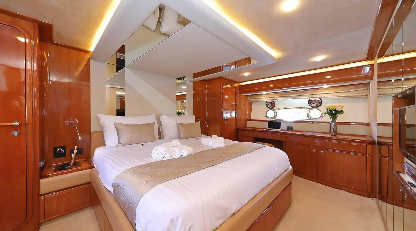 Quo Vadis I luxury yacht cabin with plush bed, warm wood paneling, and polished surfaces