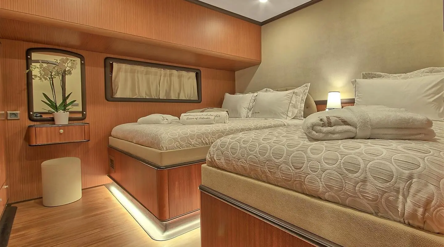 Queen Of Salmakis gulet interior with two beds and warm lighting