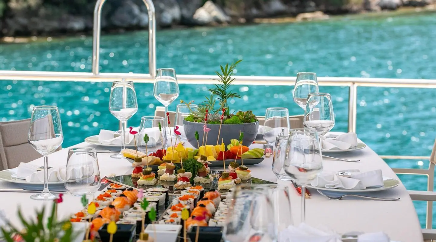Gulet Good Life table setting with food, sea view onboard in a harbor