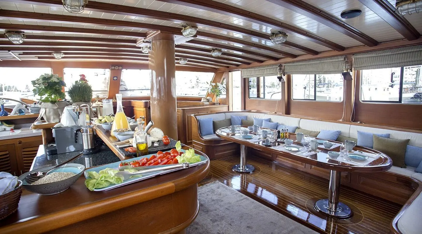 Interior of Entre Cielos yacht with polished wood, seating, and bar area.