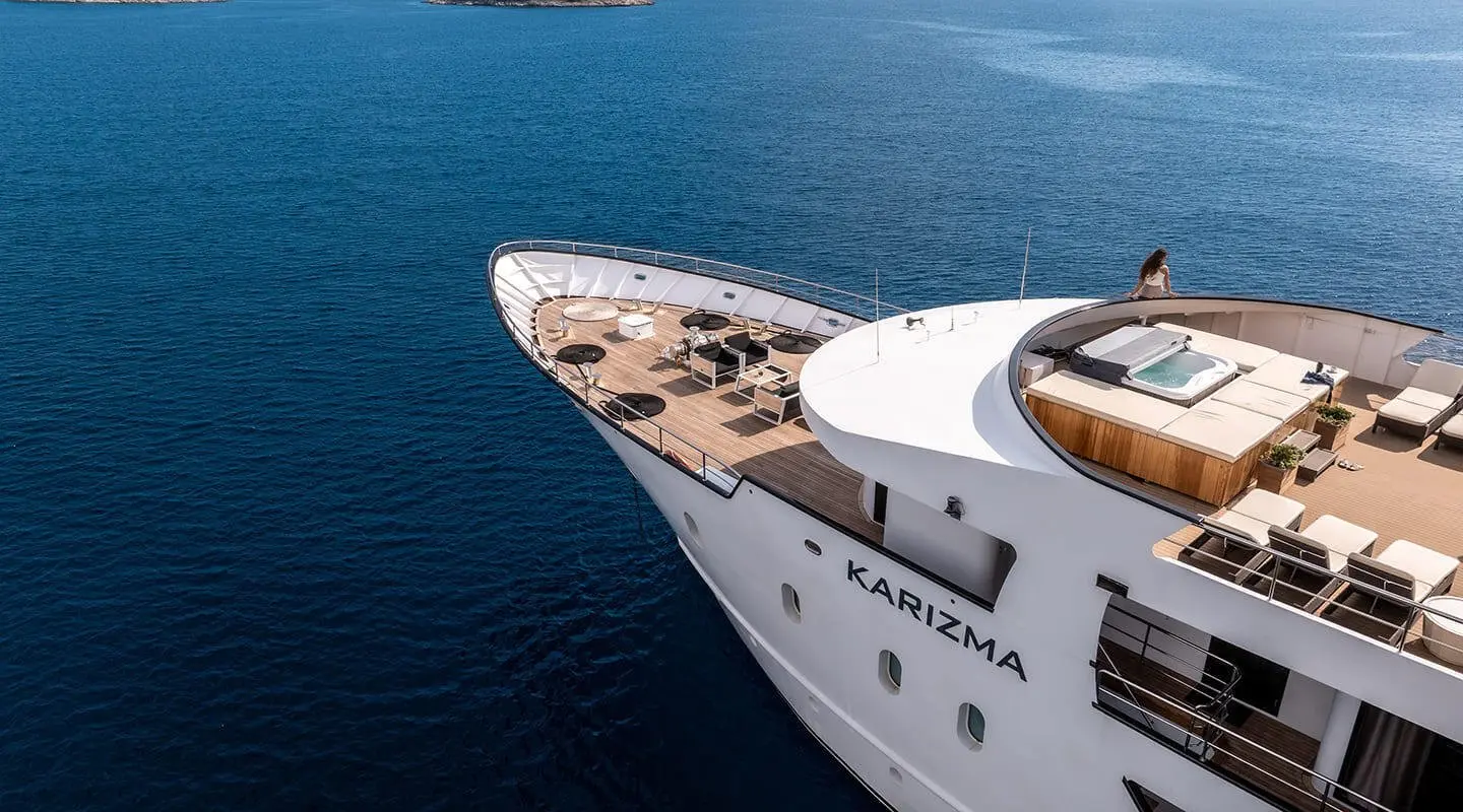 Top deck of Karizma yacht with sun loungers overlooking calm sea