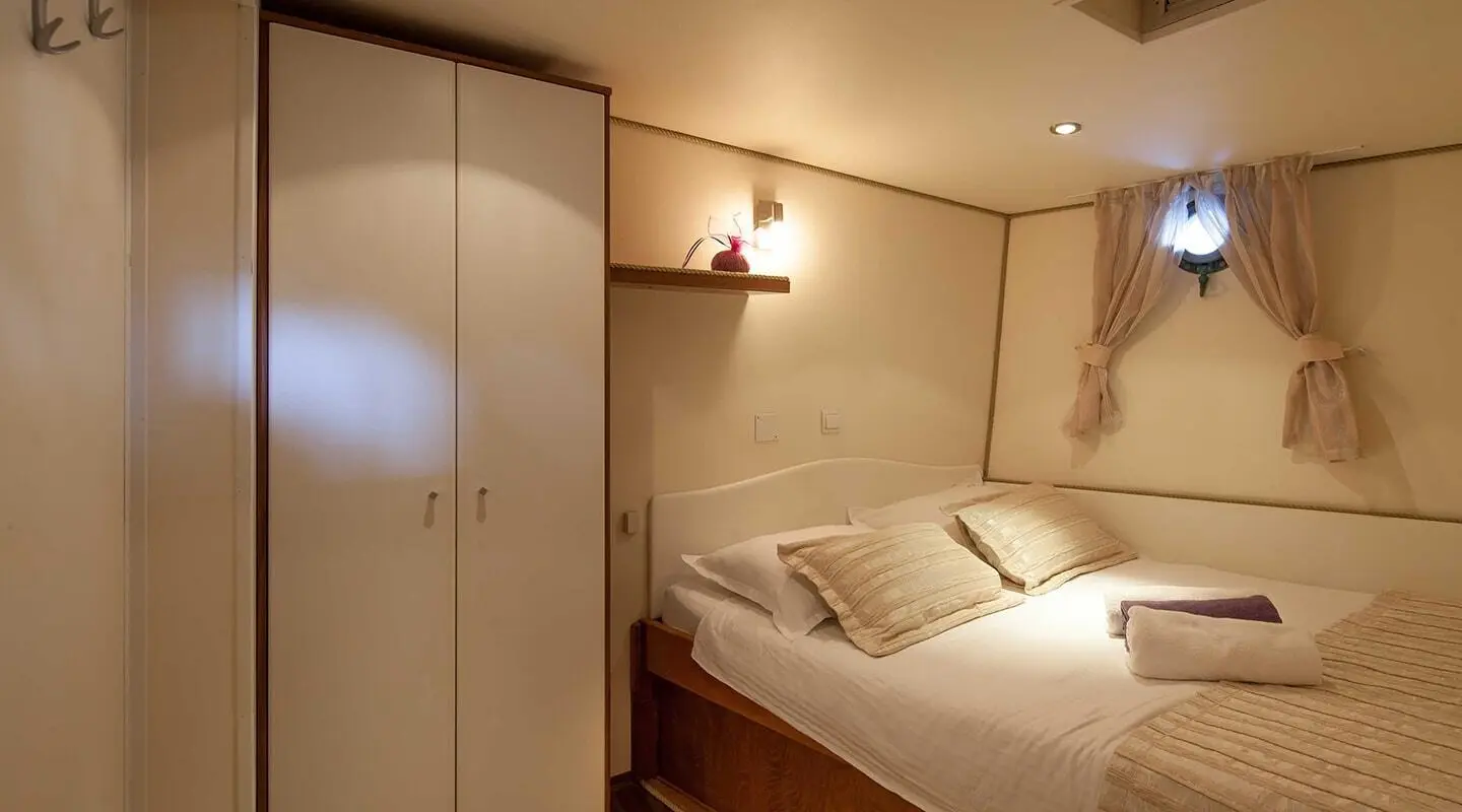 Romanca yacht charter interior with a cozy bed and warm lighting