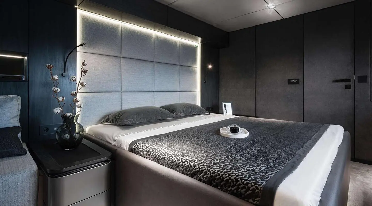 Interior of Alteya yacht with dark woven bed covers and window view