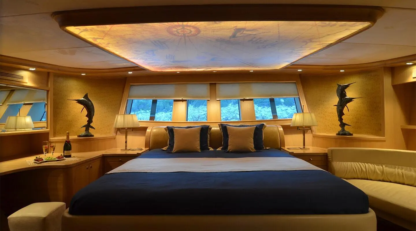 Interior cabin with bed, pillows, and warm lighting aboard Blue Heaven yacht