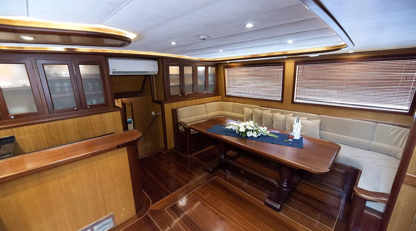 Kayhan 3 yacht interior: polished wooden decks, leather seating, and cream cushions