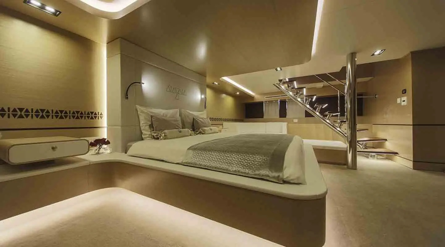 Omnia yacht interior with a luxurious bed, warm lighting, and sleek modern décor