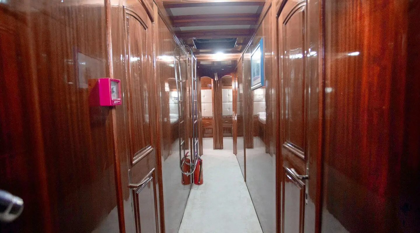 Interior corridor of a yacht with polished wooden walls and doors