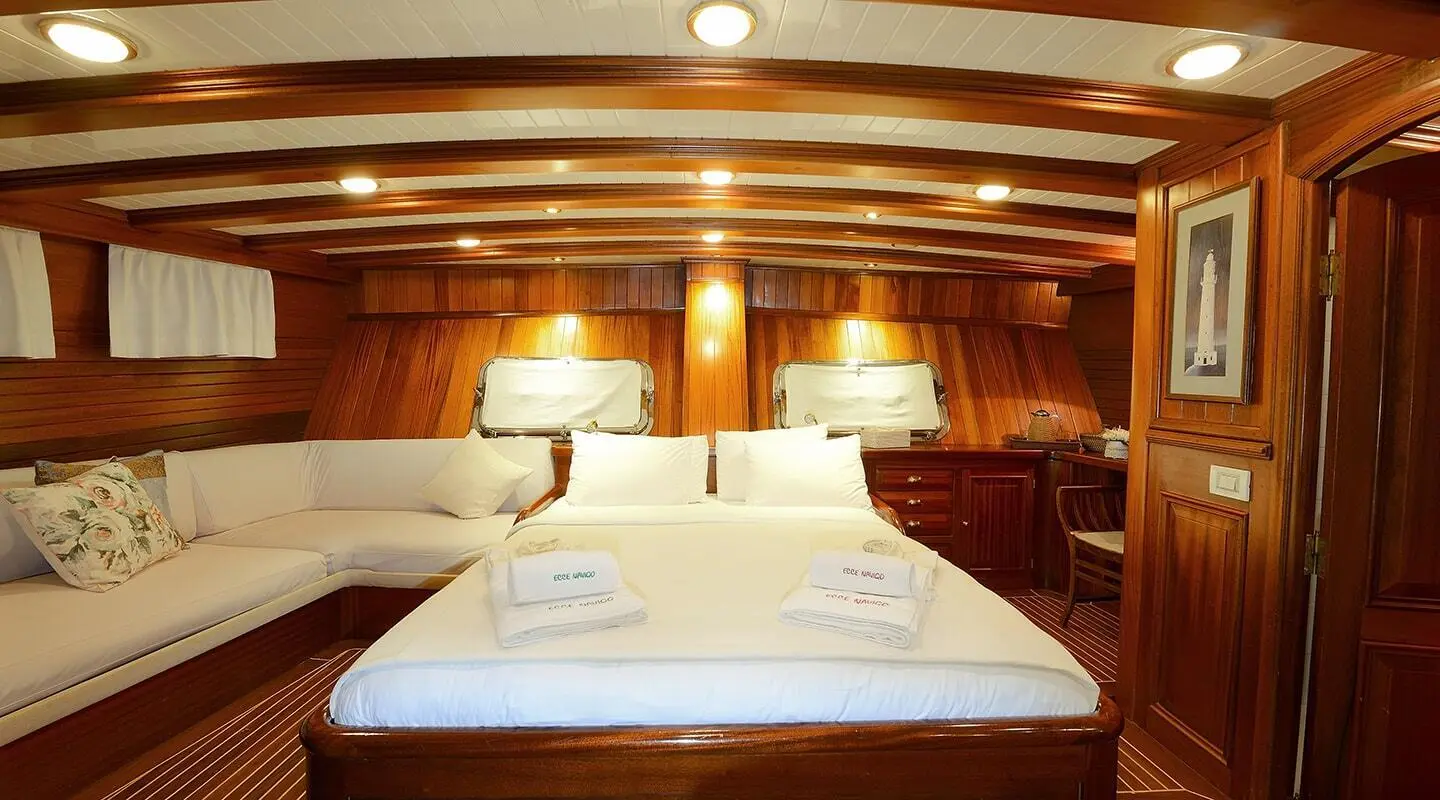 Ecce Navigo master cabin on gulet: twin beds, wood paneling, bedside lamps