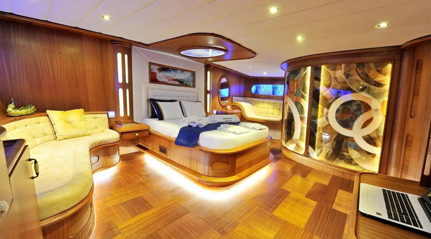 Sunset-lit luxury gulet interior with wooden accents, sea view windows