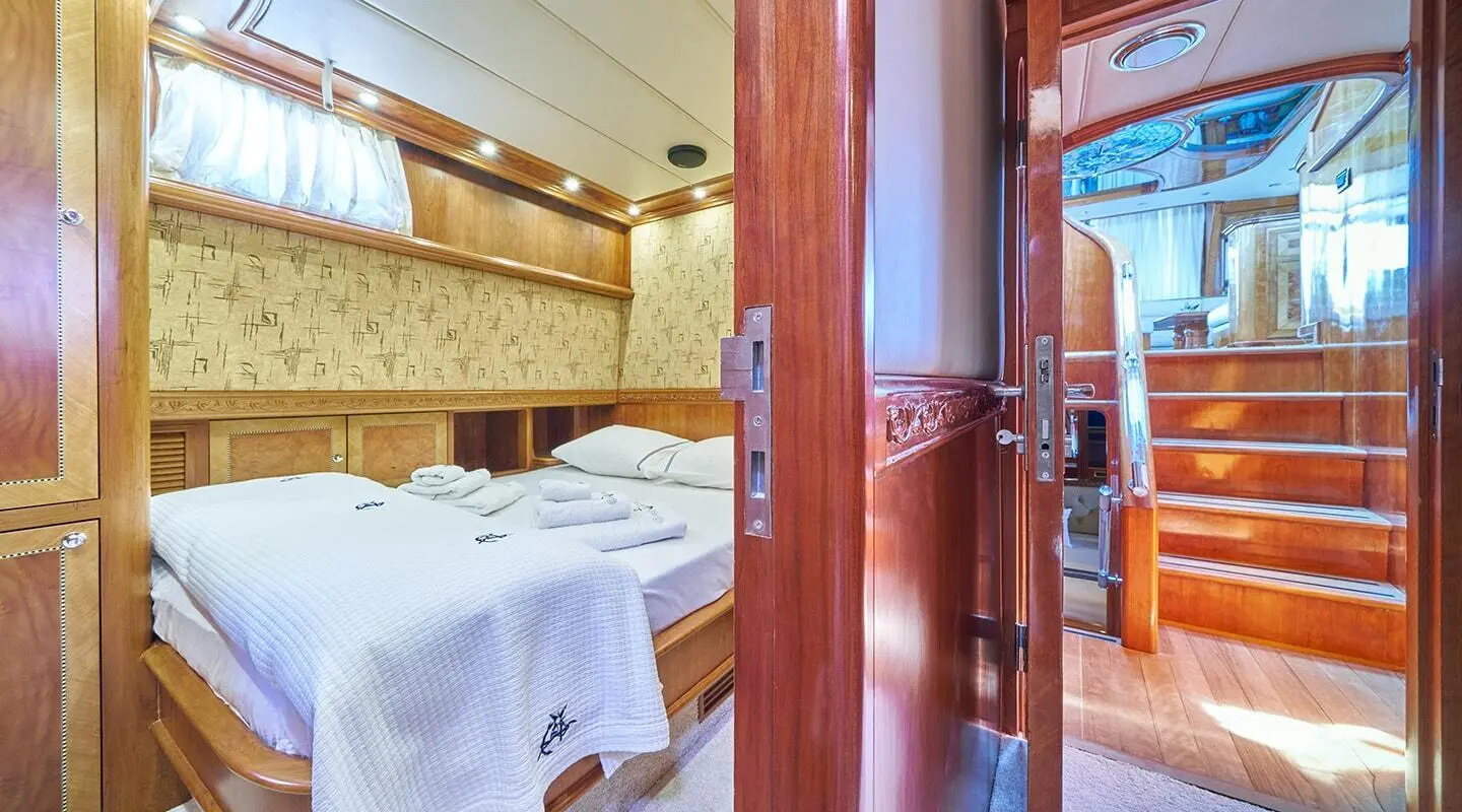Lotus yacht interior with polished wooden doors and elegant bed in cabin