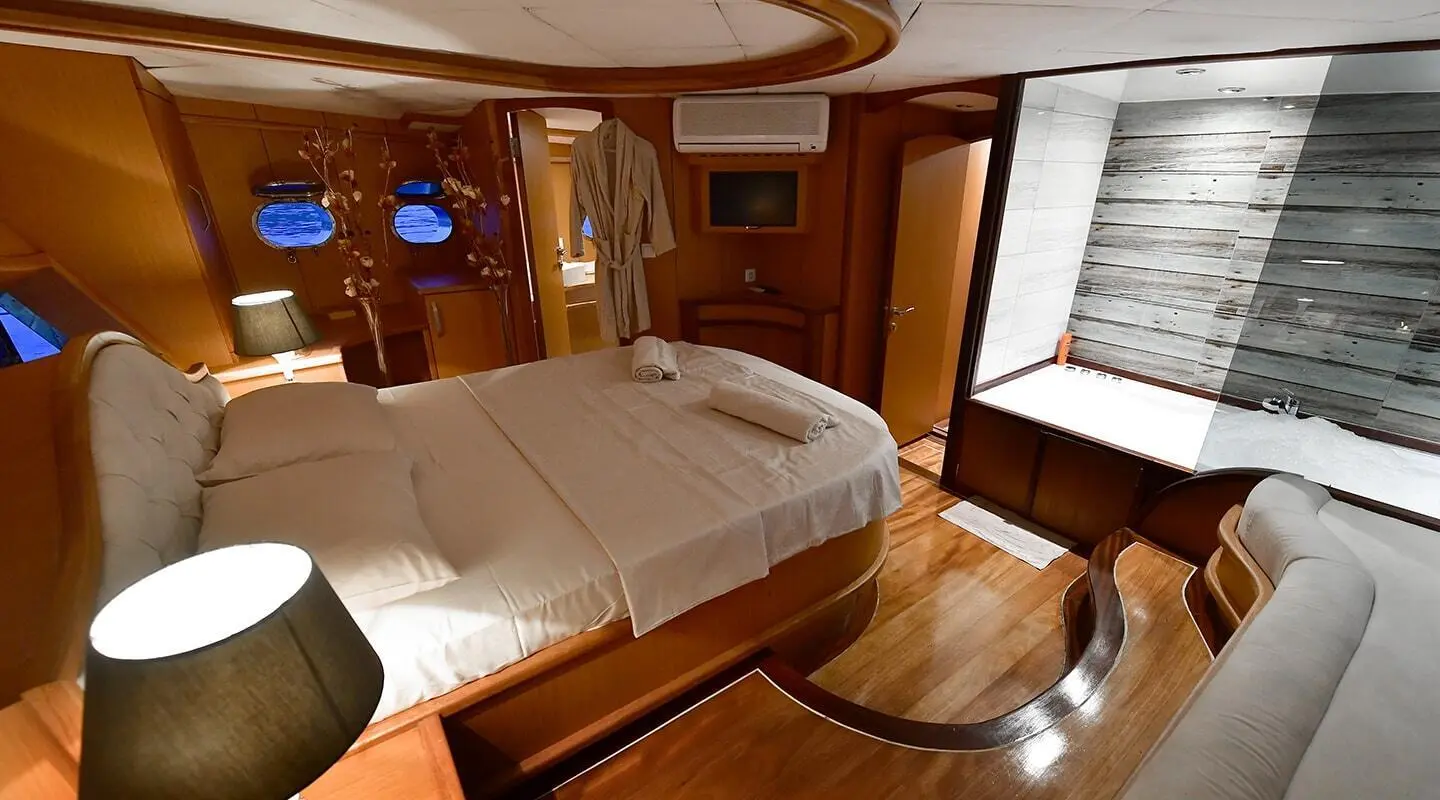 Blu Dream luxury yacht cabin with large bed, wooden accents, and ensuite bath access