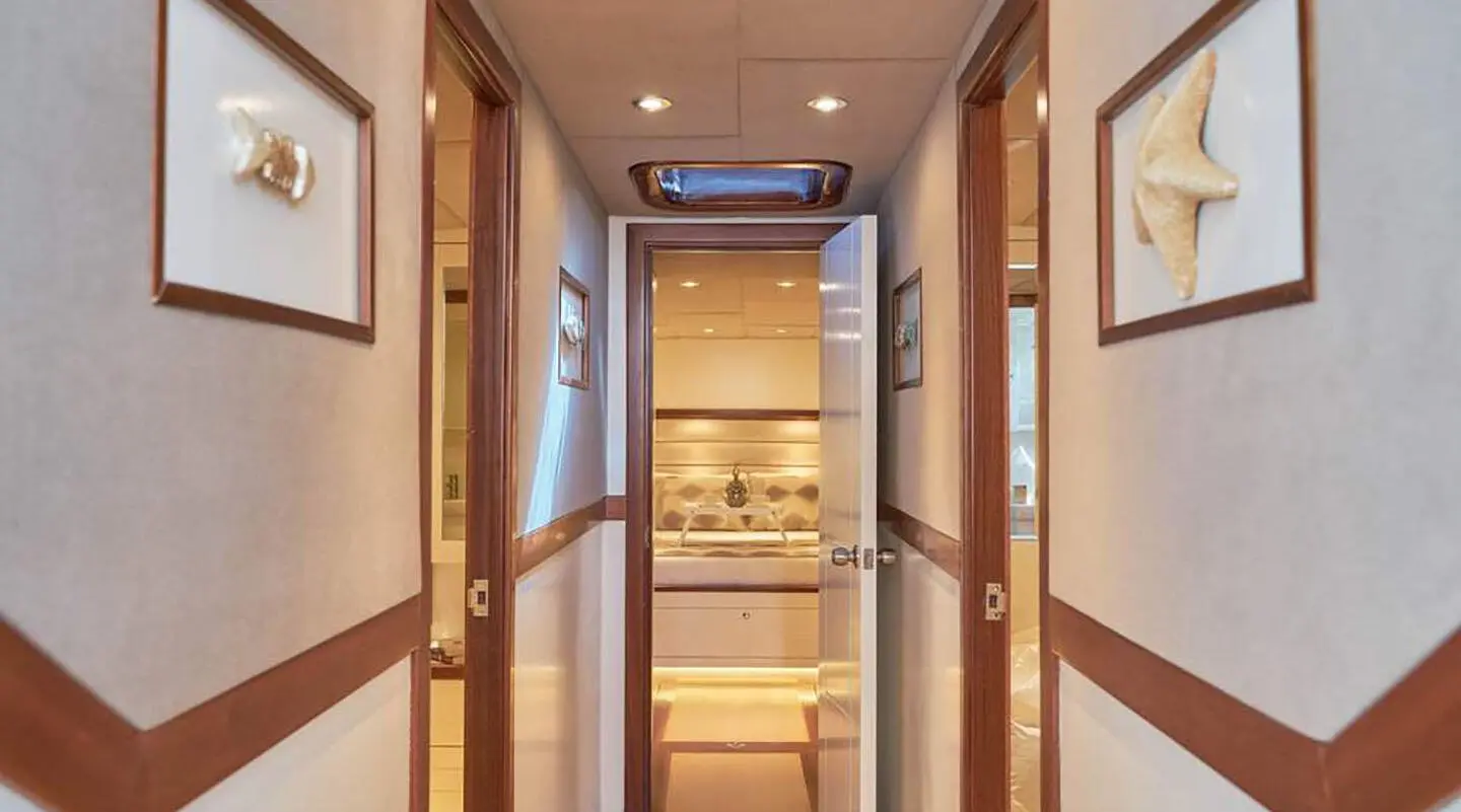 Interior hallway of a luxury yacht with polished wood panels and framed pictures