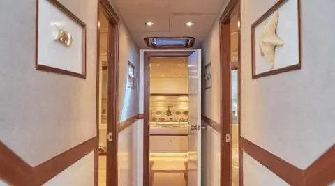 Interior hallway of a luxury yacht with polished wood panels and framed pictures
