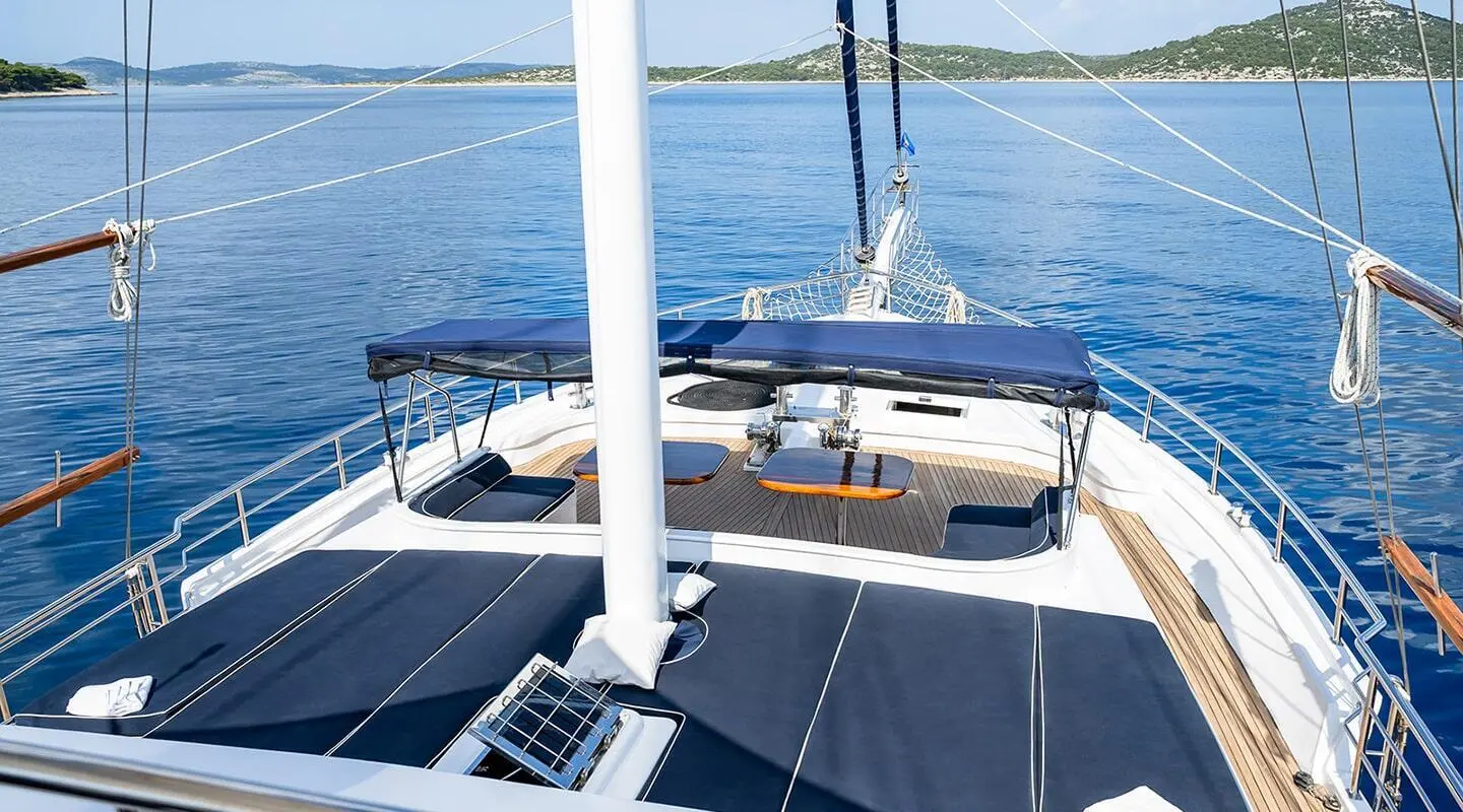 Aurum yacht deck scene at sunset with seating, railing, and calm sea view