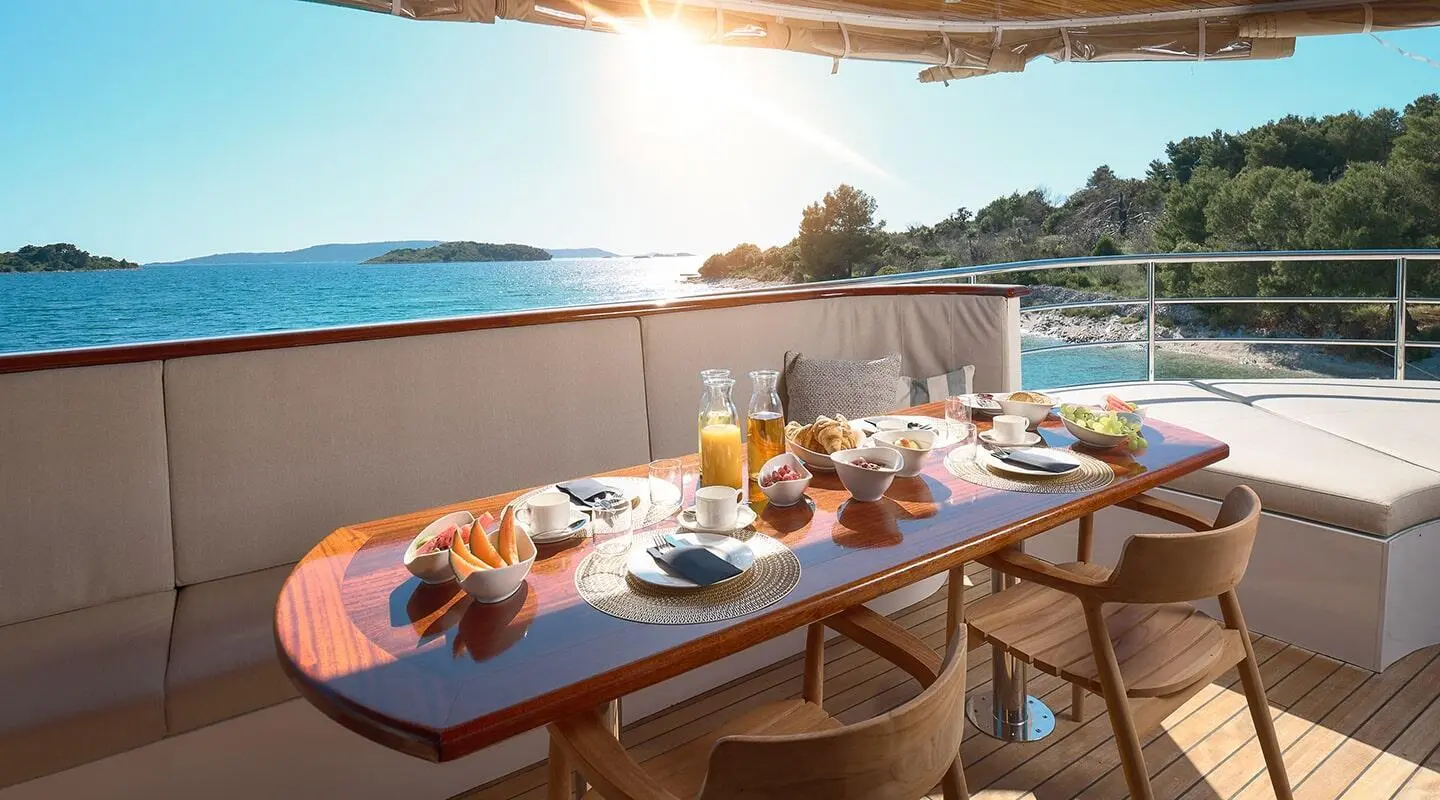 Dining table on the deck with breakfast setup and sea view